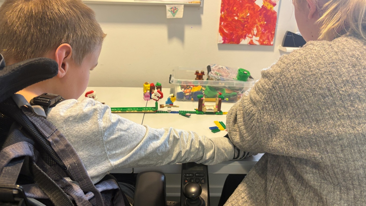 Borger og ansat bygger lego close up