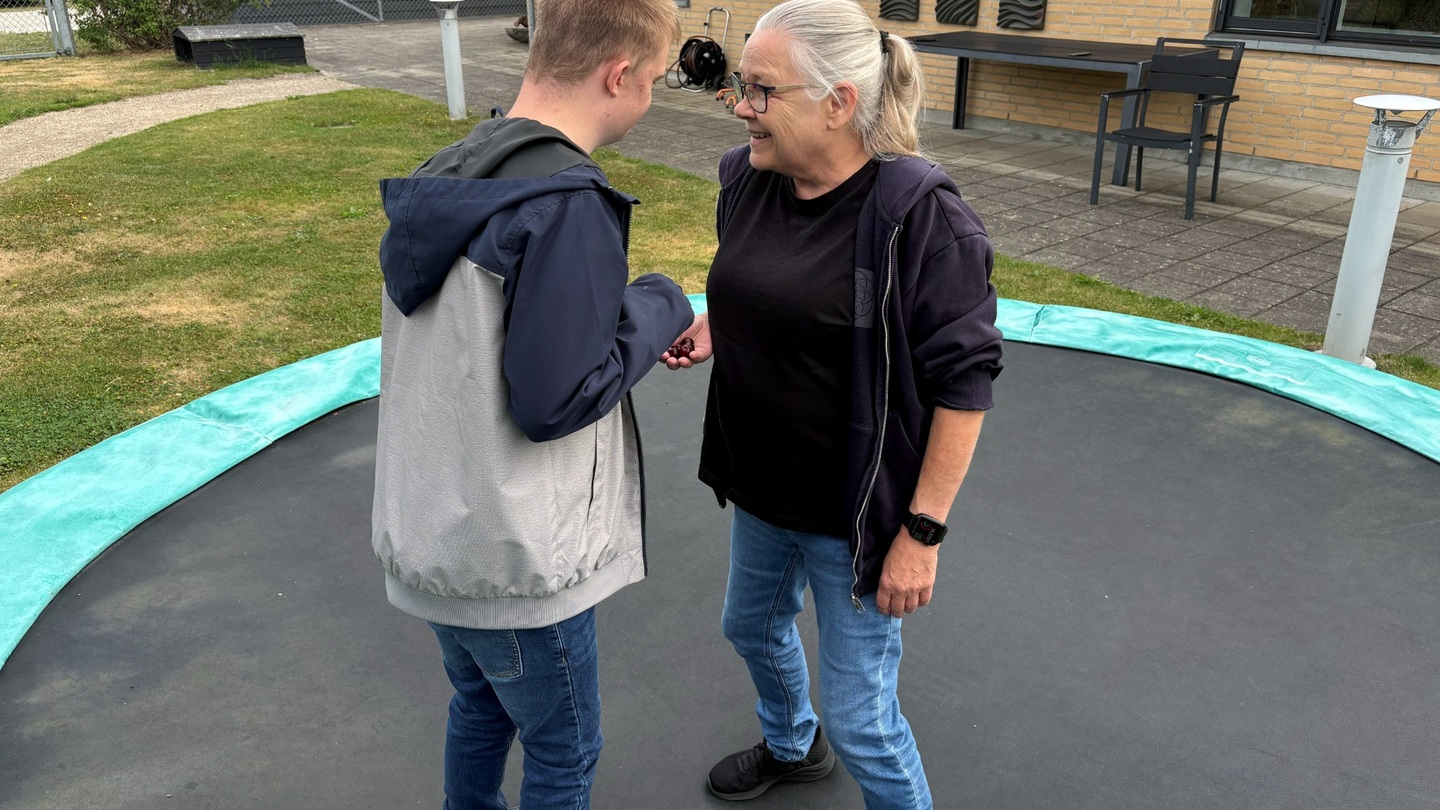 Ansat og ung på trampolin udenfor