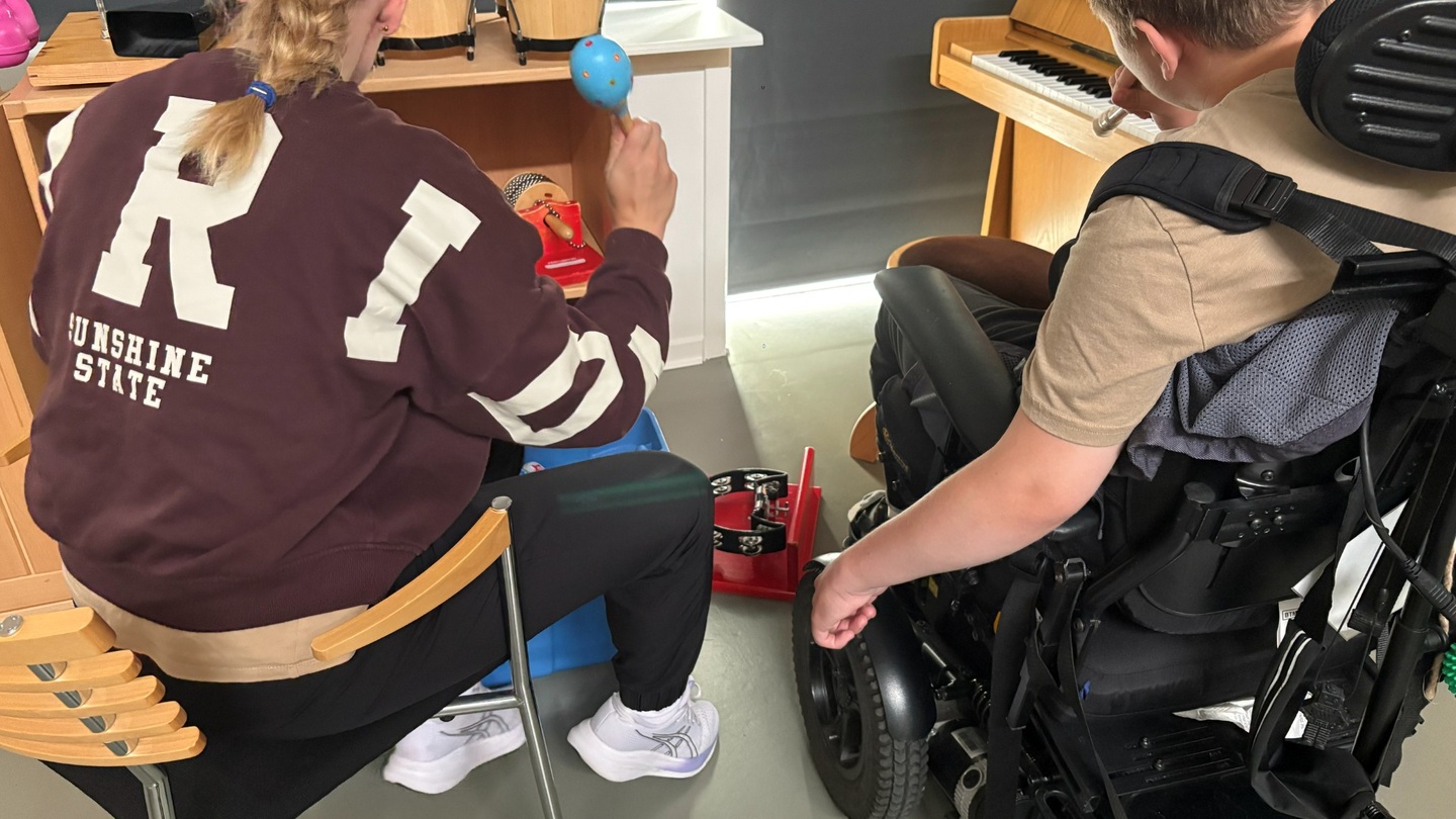 barn og ansat spiller på musikinstrumenter